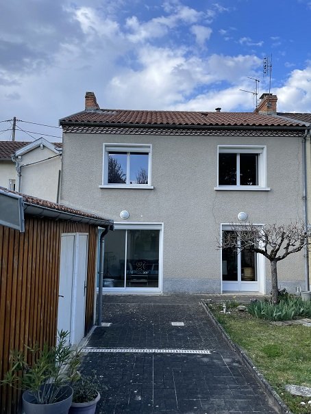 Maison de quartier avec jardin et garage.