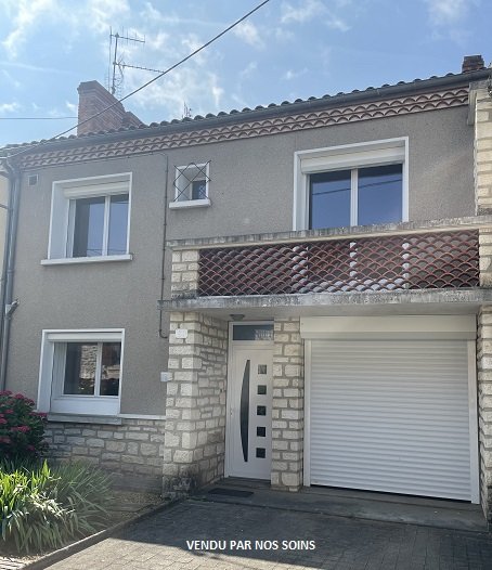 Maison de quartier avec jardin et garage.