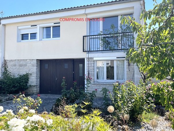 Maison avec garage et jardin.